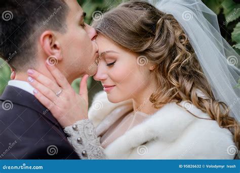 Brunette Groom Kisses Brideand X27s Forehead Tenderly Stock Photo