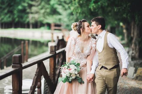 Beautiful Bride And Groom Embracing And Kissing On Their Wedding Day Outdoors Stock Image