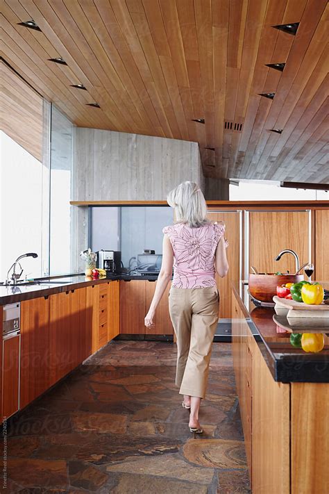Mature Woman With Grey Hair Walking In Luxury Kitchen Del Colaborador