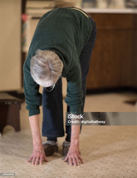 Senior Woman Bending Over To Touch Floor Stock Photo Download Image