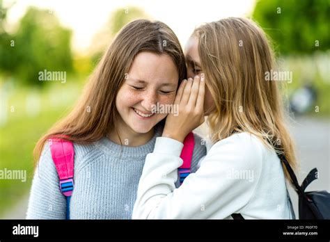 Two Girl Friends Schoolgirls Teenagers In Summer City Park Concept Of Joke Secret Fantasy