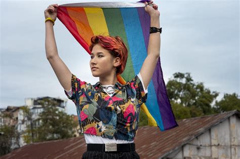 Front View Redhead Non Binary Person Holding Lgbt Flag 1 Coc Midden