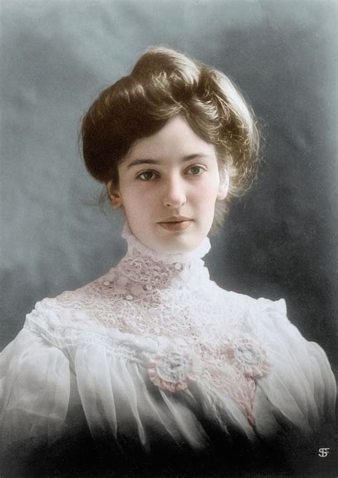 an old black and white photo of a woman wearing a lace collared blouse with her hair in a bun