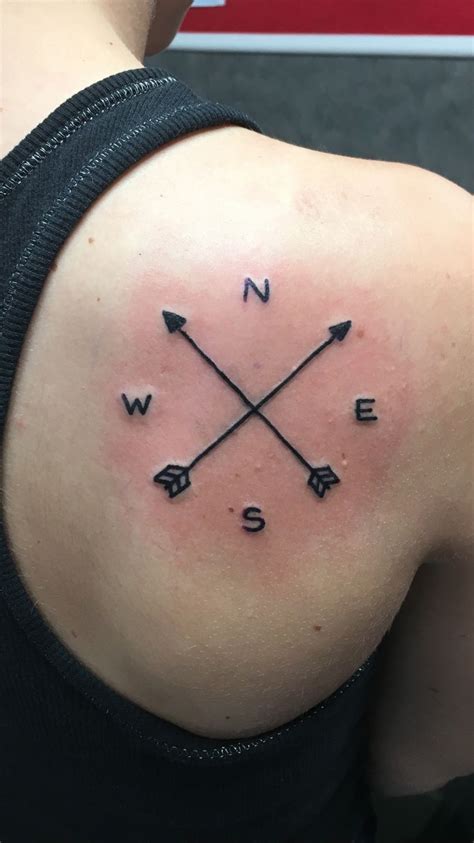 The Back Of A Womans Shoulder With Arrows And Words Tattooed On Her Arm