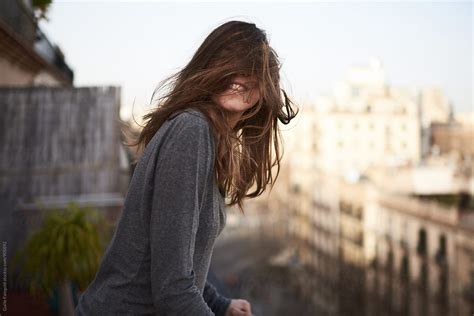 Cheerful Woman With Windy Hair Covering Her Face Del Colaborador De