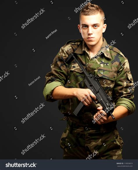 Handsome Soldier Holding Gun Against Black Stock Photo 119959819