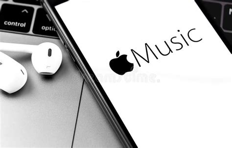 Iphone With Apple Music Logo On The Screen With Earpods Headphones