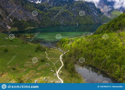 Scenic Mountain Panorama With Green Meadows And Idyllic Turquoise Lake