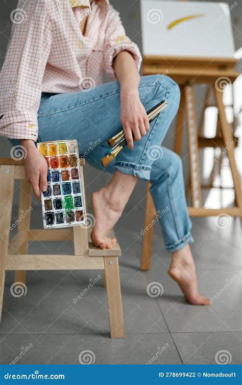 Cropped Shot Of Barefoot Female Artist Holding Drawing Tools Sitting On