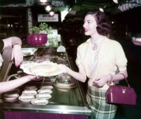 Two Women Standing In Front Of A Counter With Pastries On It And One