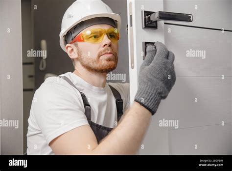 Carpenter worker installation process of wood door hinge Stock Photo