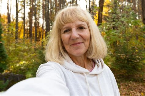 Free Photo Elder Woman Taking A Selfie While Trekking Outdoors