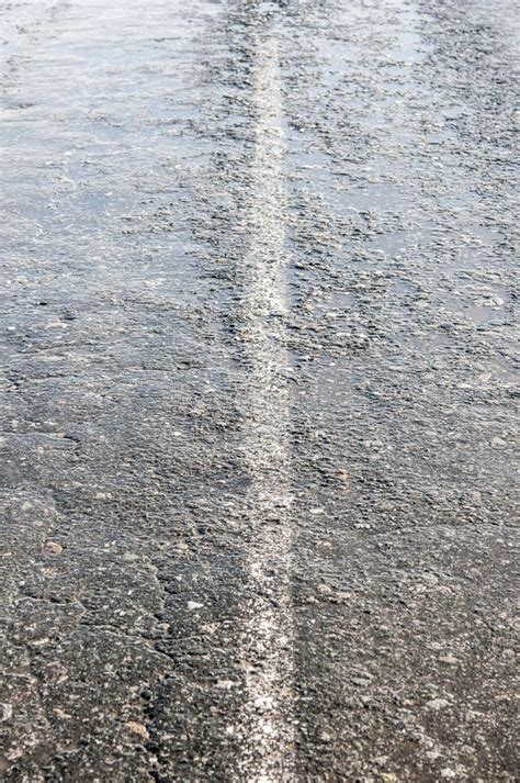 View Of Street Pavement Wet After Rain With Water Puddles Stock Photo