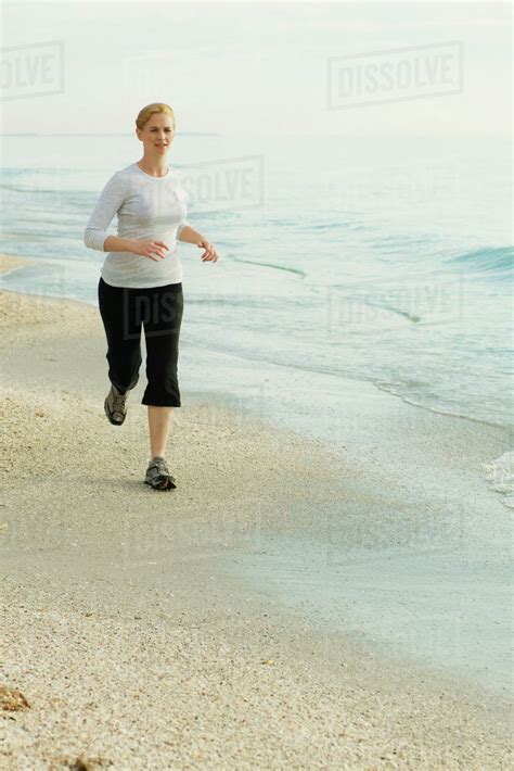Woman Running At The Beach Stock Photo Dissolve