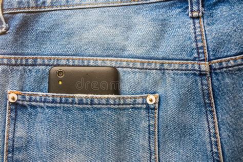 Black Smart Mobile Phone In Back Blue Jeans Pocket Denim Background