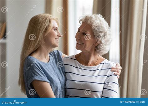 Happy Mature Mother Cuddling Warm Smiling Grownup Daughter Stock Image