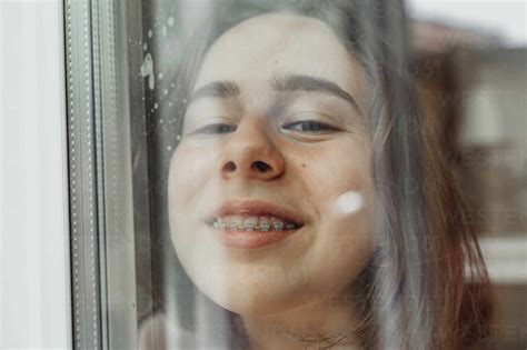 Portrait Of Smiling Teenage Girl With Dental Brace Looking Out Of