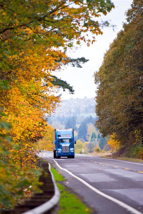 blue classic modern semi truck  winding autumn road