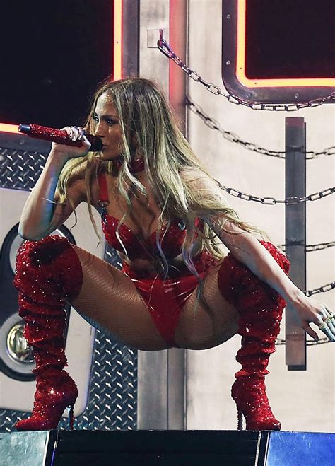 the woman is performing on stage with her legs in the air and wearing red boots