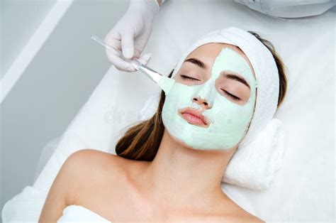 Beautiful Young Woman With Facial Mask In Beauty Salon Girl Getting