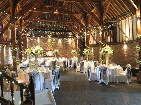 An Indoor Venue With Tables And Chairs Covered In White Linens
