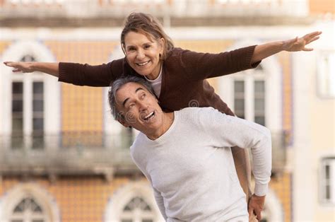 Joyful Senior Couple Having Fun Posing Husband Carrying Wife Outdoors