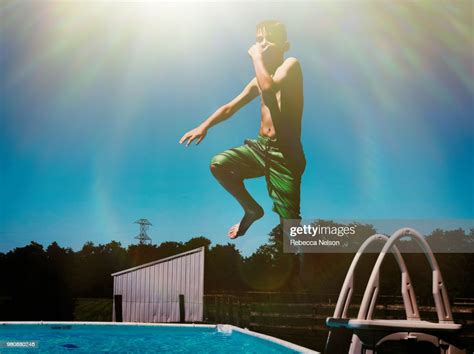 Boy Jumping Into Swimming Pool Caught Mid Air Stock Photo Getty Images