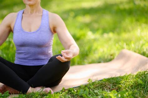 Athletic Middle Aged Woman Doing Yoga Outdoors In A City Park