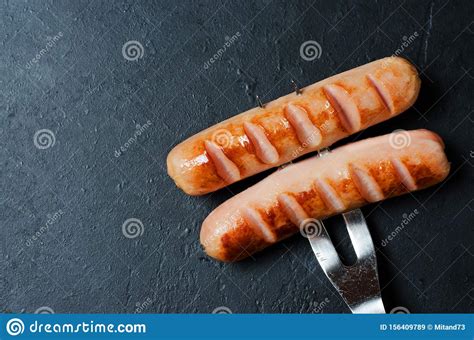 Grilled Sausages Fried On A Metal Fork Unhealthy Diet Dark Background