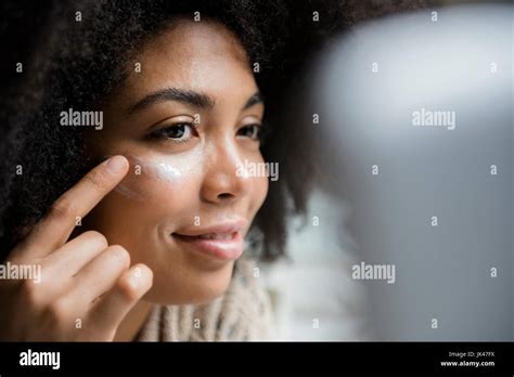 African American Woman Applying Lotion To Face Stock Photo Alamy