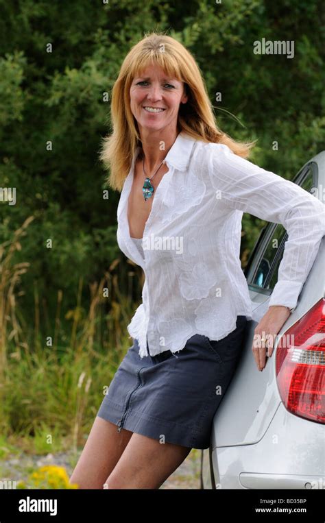 Reife Frau Trägt Ein Weißes Hemd Und Rock Stützte Sich Auf Ein Auto Stockfotografie Alamy