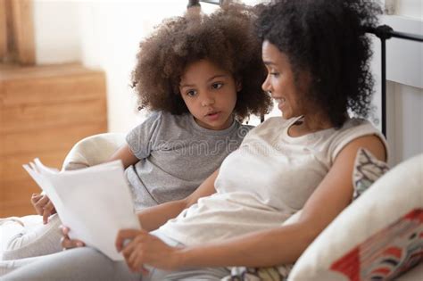 Biracial Mom Reading With Little Daughter In Bedroom Together Stock Image Image Of Enjoy