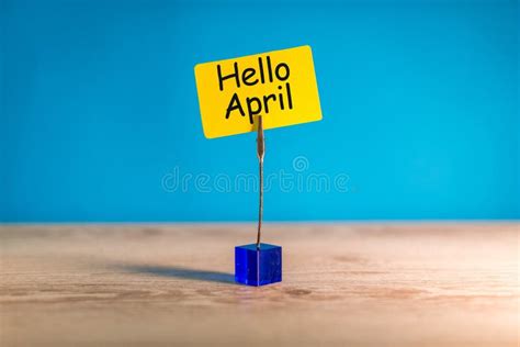 Hello April Greeting Written On Yellow Tag At Wooden Desk Stock Photo