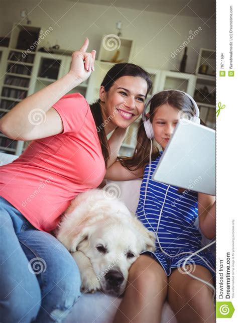 Madre Feliz E Hija Que Se Sientan Con El Perro Casero Y El Usar Digital