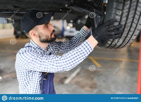 Auto Mechanic Working Underneath A Lifted Car Stock Image Image Of