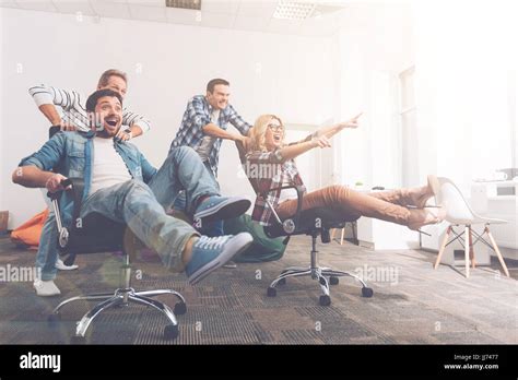 Cheerful Colleagues Having Fun In Office Chairs Stock Photo Alamy
