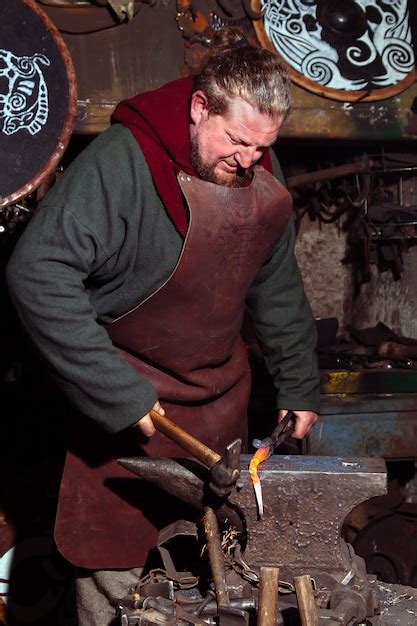 Premium Photo Viking Blacksmith Forges Weapons In The Old Vintage Forge