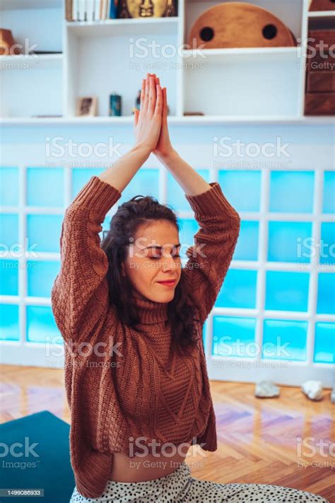 Girl Sitting With Her Eyes Closed And Her Hands Above The Head In A