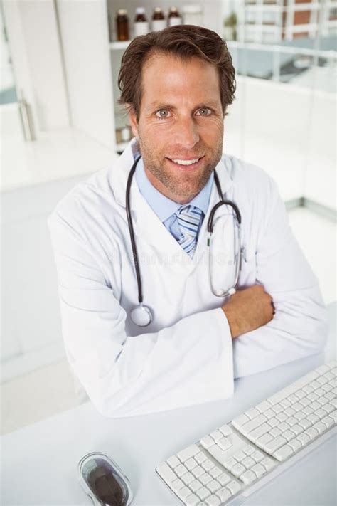 Smiling Male Doctor Sitting At Medical Office Stock Photo Image Of