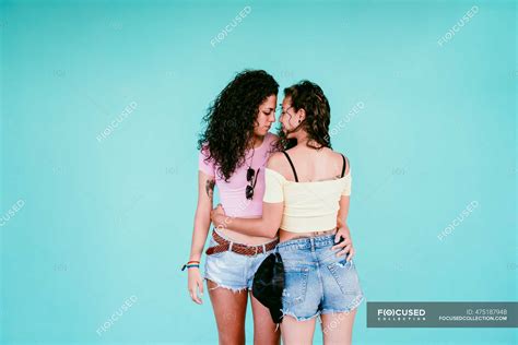 Romantic Lesbian Couple Embracing While Standing Against Blue Wall In City Spain Falling In