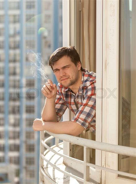Young Man Smoking Cigarette On Balcony Stock Image Colourbox