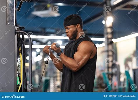 Concentrated Black Sportsman Training Muscles On Block Exerciser In Gym