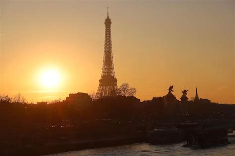 Romántico atardecer de fondo torre eiffel con barcos en el río sena en