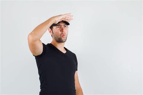 Free Photo Young Man Looking Far Away With Hand Over Head In Black T
