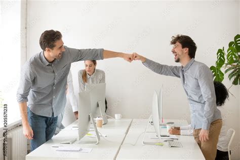 Cheerful Male Colleagues Fist Bumping Celebrating Successful Teamwork In Office Friendly Happy