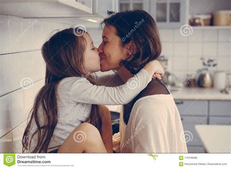 Het Mamma Kust Haar Weinig Dochter In De Keuken Stock Foto