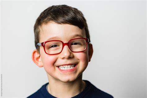 Studio Portrait Of A Smiling Child With Glasses By Stocksy