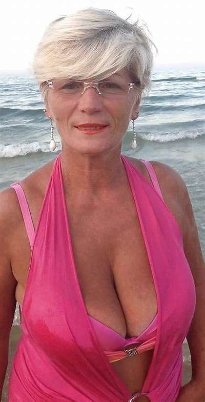 An Older Woman In A Pink Swimsuit On The Beach