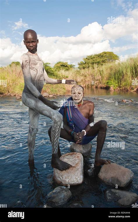 Deux hommes Surma avec peintures du visage et du corps dans la rivière