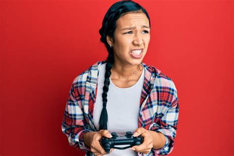 Beautiful Hispanic Woman Playing Video Game Holding Controller Angry